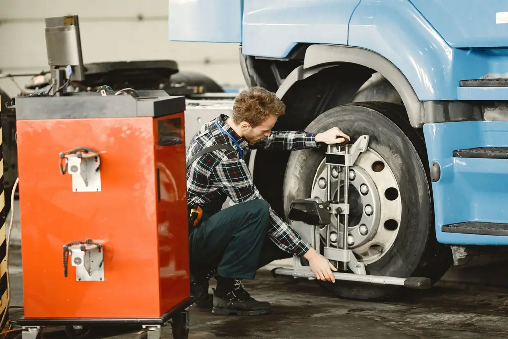 Technician servicing the front wheel of a commercial truck